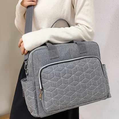 Sac à langer pratique gris porté à l'épaule par une femme – design moderne et élégant