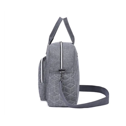 Vue latérale du sac à langer gris montrant sa largeur et sa forme compacte